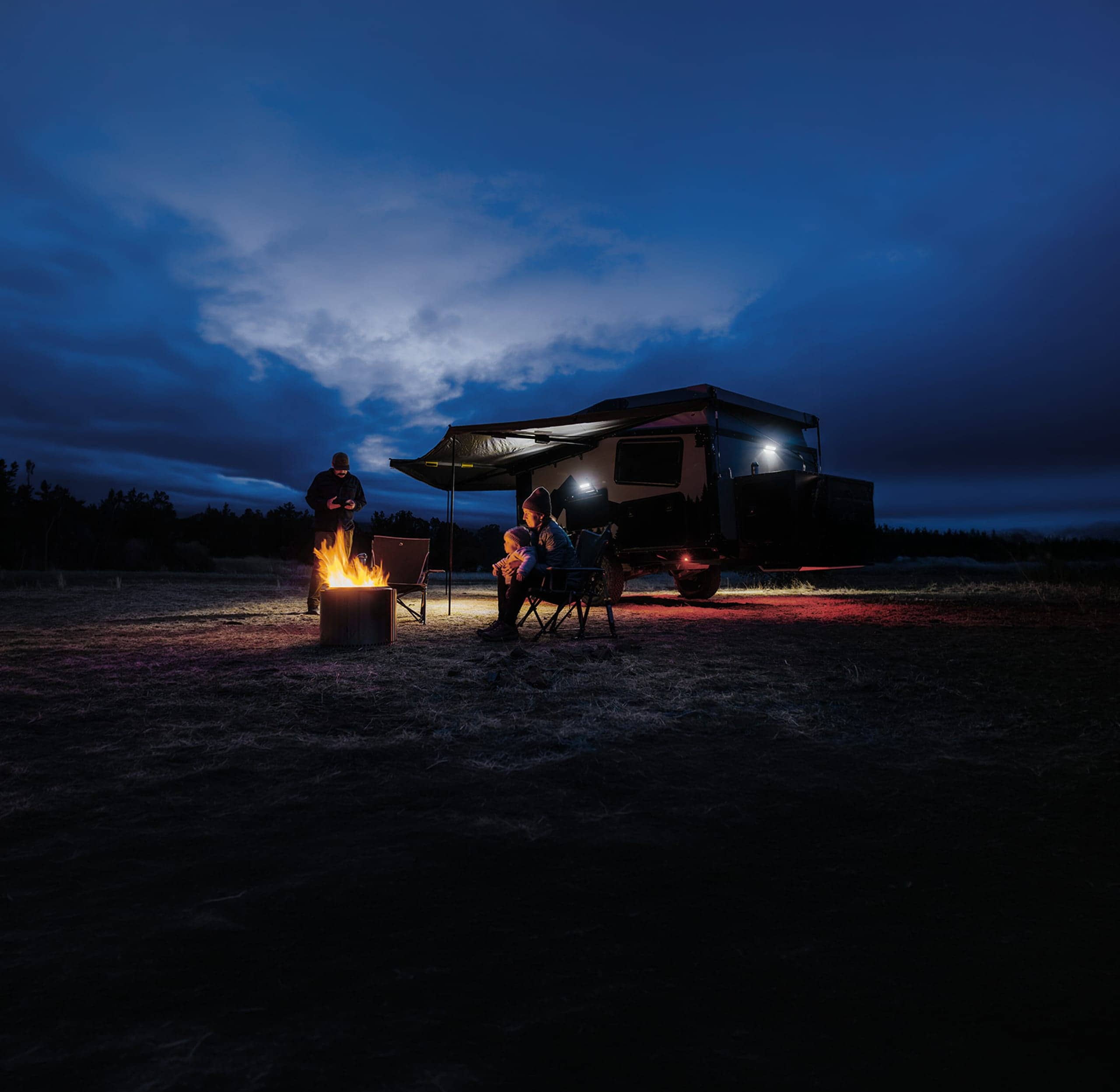 Autocaravana familiar estacionada à noite com luzes brilhantes