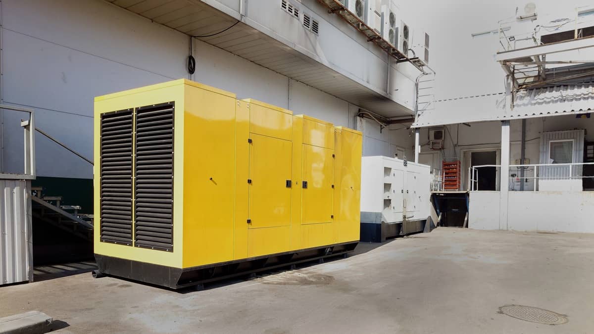 Um grande gerador amarelo num pátio industrial
