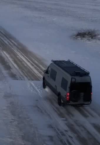Furgão médico estacionado em uma estrada vicinal coberta de neve