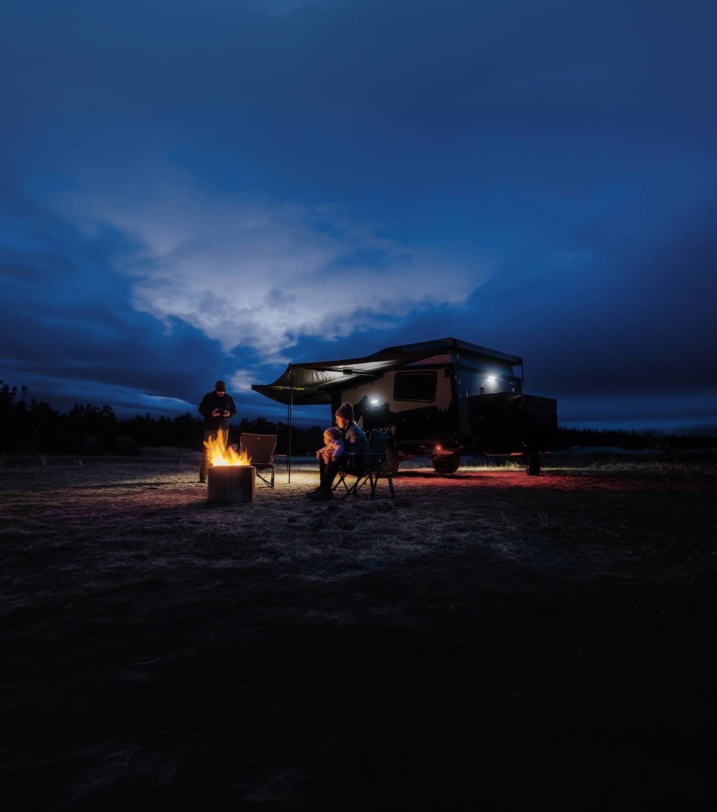 Autocaravana familiar estacionada à noite com luzes brilhantes
