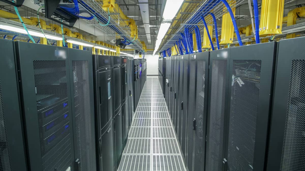 Filas de bastidores de servidores no corredor de um centro de dados